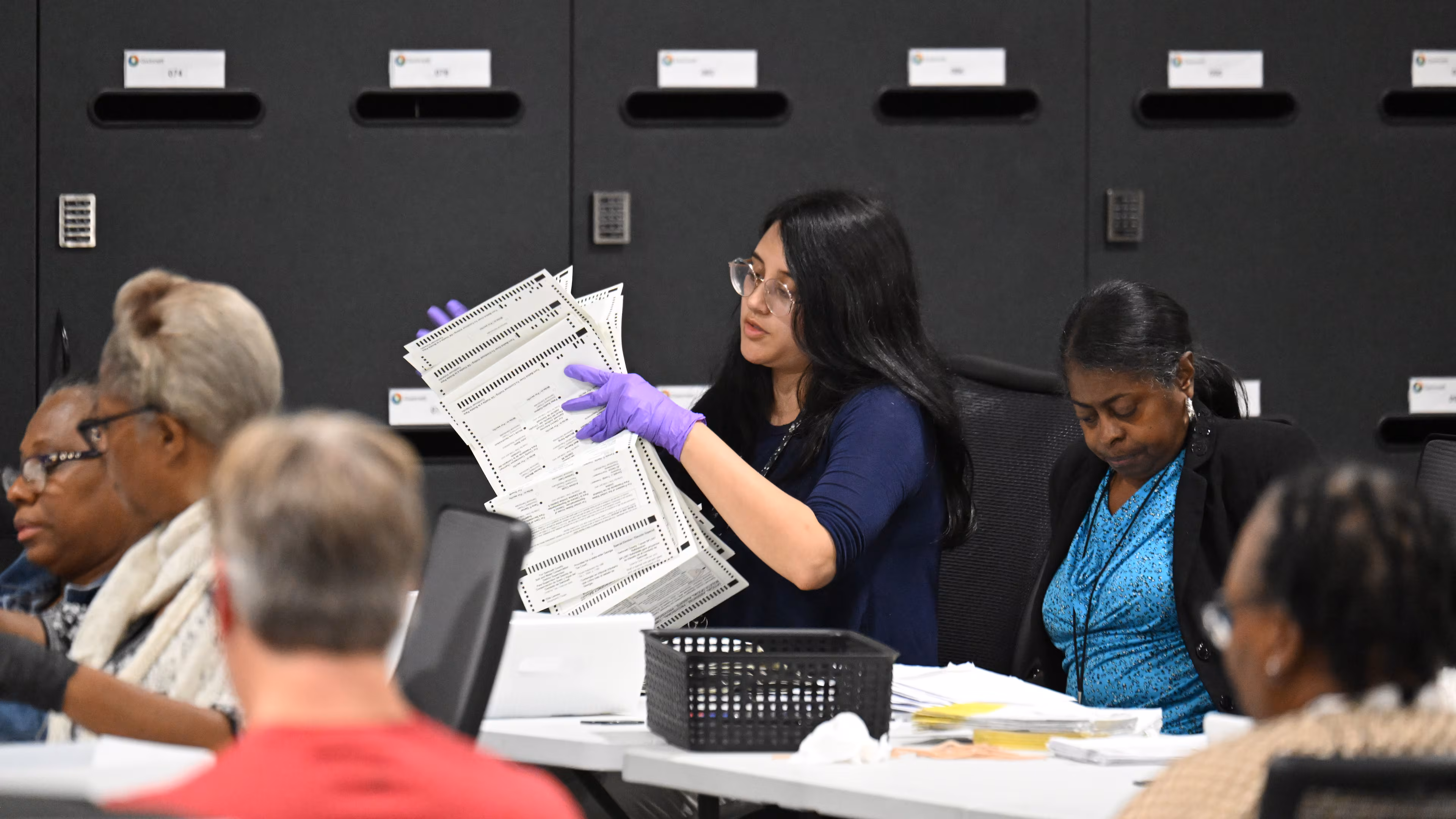 Georgia election officials reviewing paper ballots at a county tabulation center