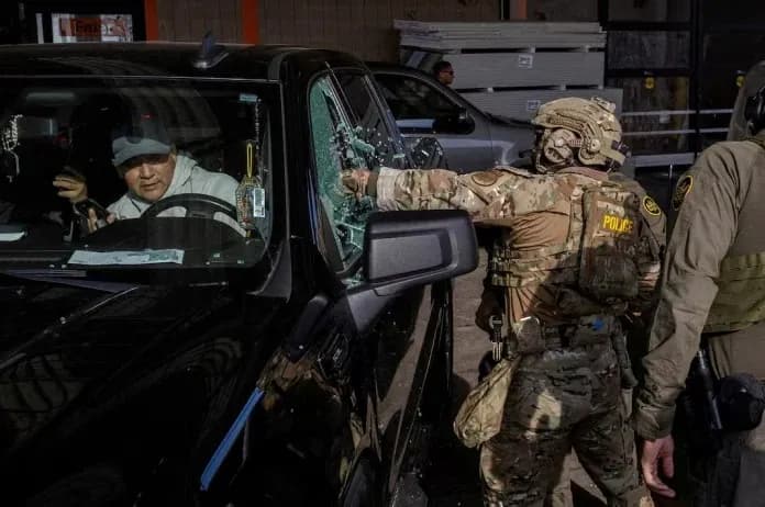 Legal observers in purple vests standing near ICE enforcement activity