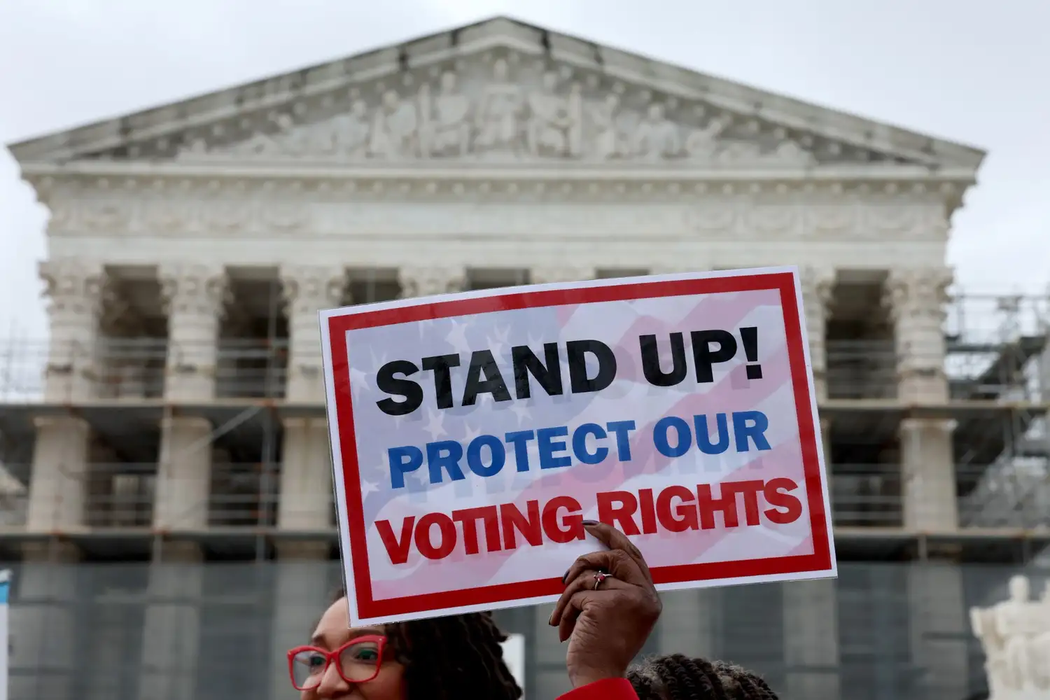 Protesters outside federal courthouse holding signs defending voter data privacy