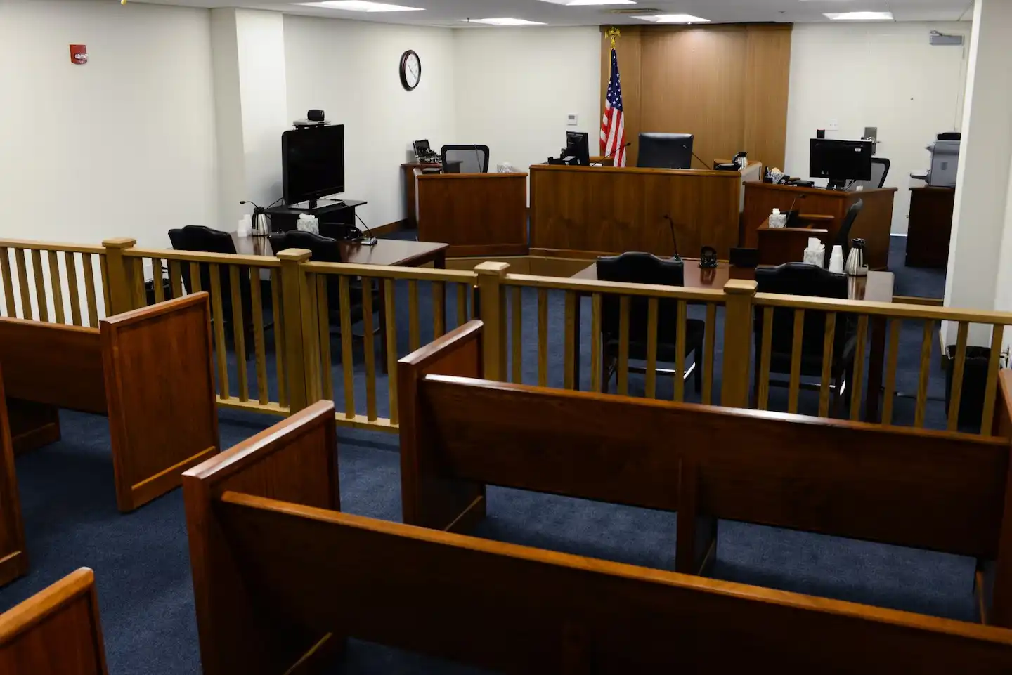 Immigration court hallway with American flag and wooden benches