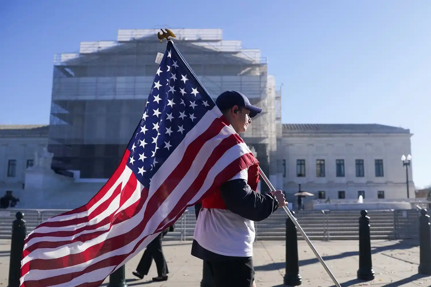 U.S. Supreme Court building with flags and tariff-related protest signage