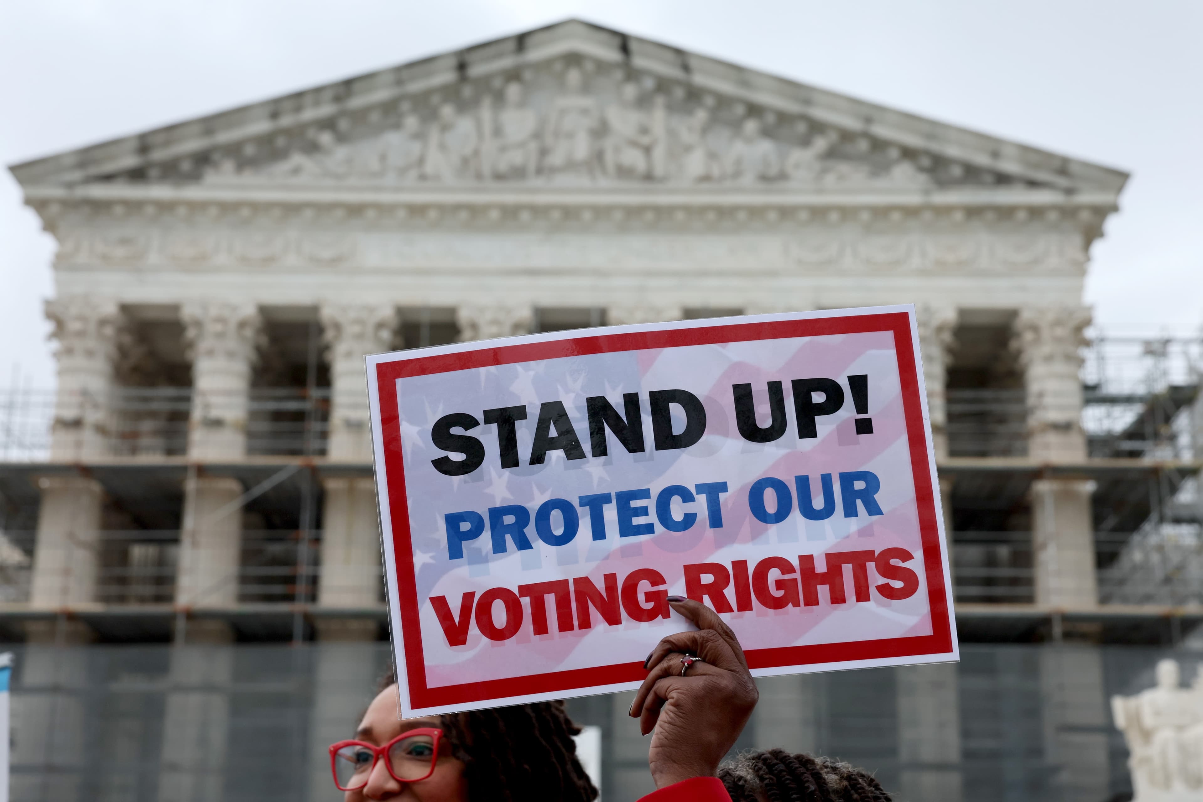 Civil rights advocates react outside the Supreme Court following the Voting Rights Act ruling