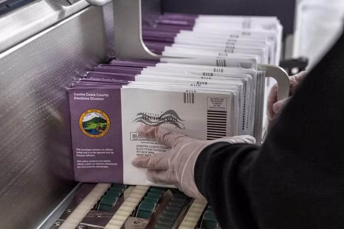 Stack of mail ballots and envelopes awaiting processing